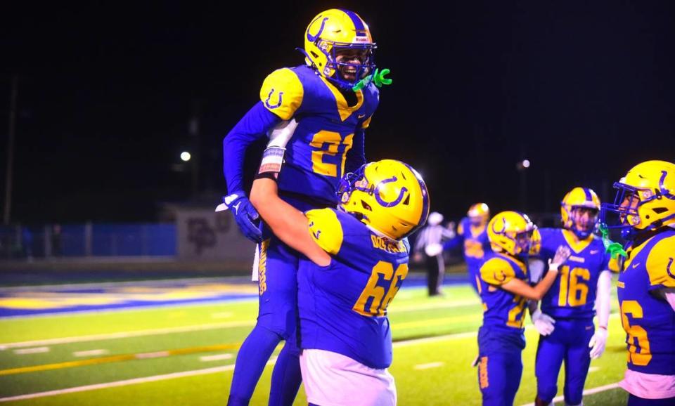 Dos Palos High School sophomore Esteban Hernandez (66) lifts teammate Sixto Ibarra (21) up in the air after Ibarra scored a touchdown on an interception return in the first half against Coalinga on Friday, Oct. 28, 2023 in Dos Palos, Calif.