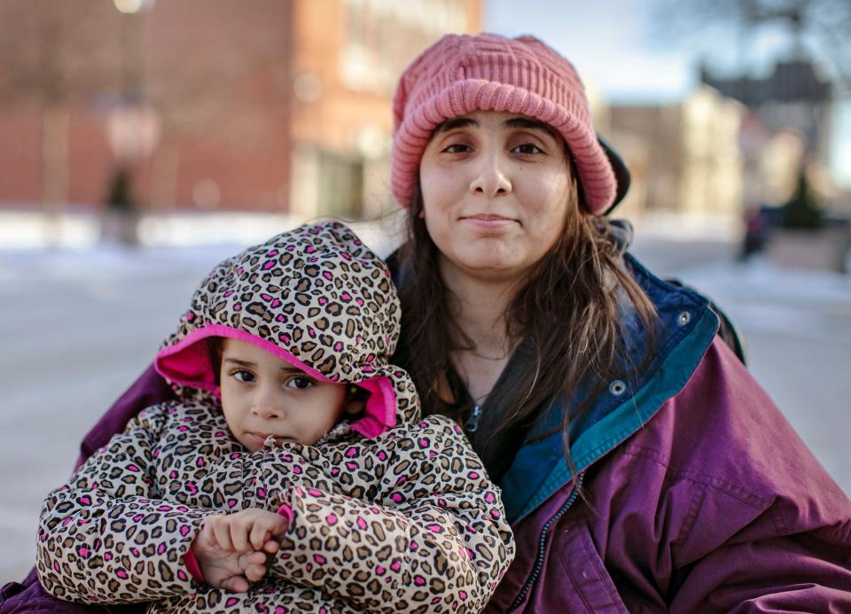 Ashley Lagoo-Mckinnie and her daughter, Lyanna Brown-Lagoo, sit on the corner near the Above and Beyond Children's Museum, Friday, January 28, 2022, in Sheboygan, Wis. Ashley, who uses a wheelchair, and her young daughter live in a shelter in Sheboygan. The shelter has everyone leave in the morning and not return until the late afternoon, no matter what the temperature outside is.