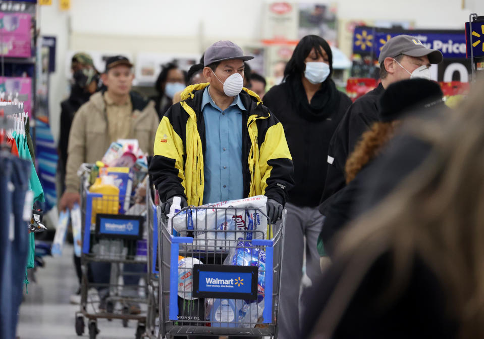 UNIONDALE, NEW YORK - APRIL 03:  People wearing masks and gloves wait to checkout at Walmart on April 03, 2020 in Uniondale, New York. The World Health Organization declared coronavirus (COVID-19) a global pandemic on March 11th.  (Photo by Al Bello/Getty Images)