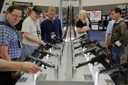 Attendees look at Browning handguns inside of the convention hall during the National Rifle Association (NRA) annual meeting in Dallas, Texas, U.S., May 4, 2018. REUTERS/Lucas Jackson