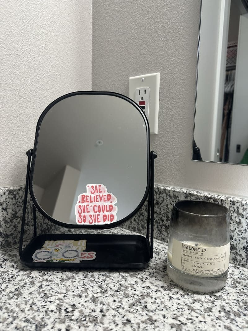 bathroom granite look countertop with small mirrot and candle