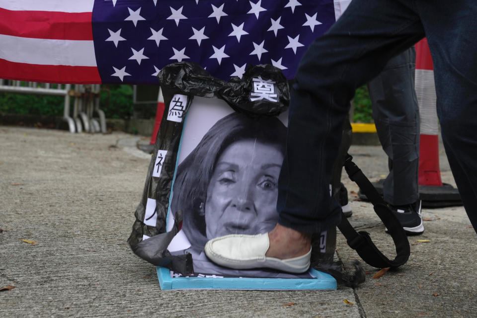 Pro-China supporters step on a picture of U.S. House Speaker Nancy Pelosi during a protest outside the Consulate General of the United States in Hong Kong, Wednesday, Aug. 3, 2022. U.S. House Speaker Nancy Pelosi arrived in Taiwan late Tuesday, becoming the highest-ranking American official in 25 years to visit the self-ruled island claimed by China, which quickly announced that it would conduct military maneuvers in retaliation for her presence. (AP Photo/Kin Cheung)