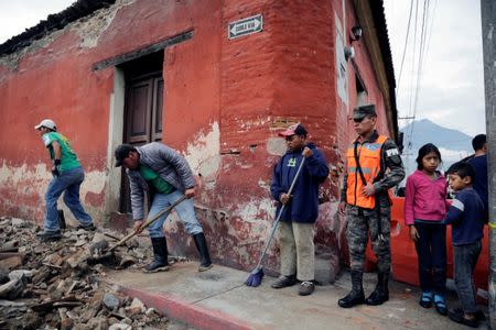 Municipal workers remove debris from a damaged house after an earthquake in Antigua, Guatemala June 22, 2017. REUTERS/Luis Echeverria
