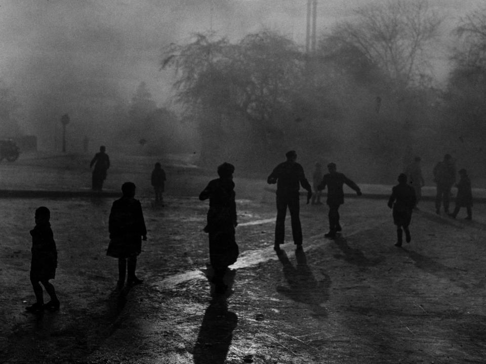 Boys sliding on the ice in the fog at Hampstead Heath ponds on December 7, 1952.