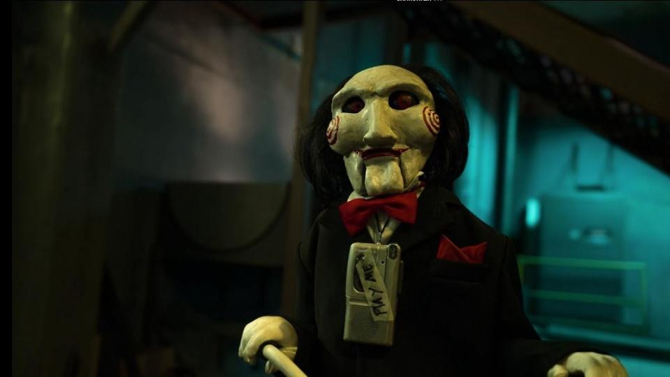 billy the puppet wears a tape player that says 