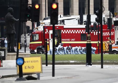 Police officers search an area of Parliament Square the morning after an attack in London, Britain, March 23, 2017. REUTERS/Stefan Wermuth