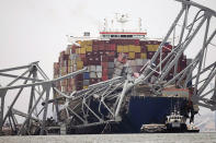 A cargo ship is stuck under the part of the structure of the Francis Scott Key Bridge after the ship hit the bridge Wednesday, March 27, 2024, in Baltimore, Md. (AP Photo/Steve Helber)