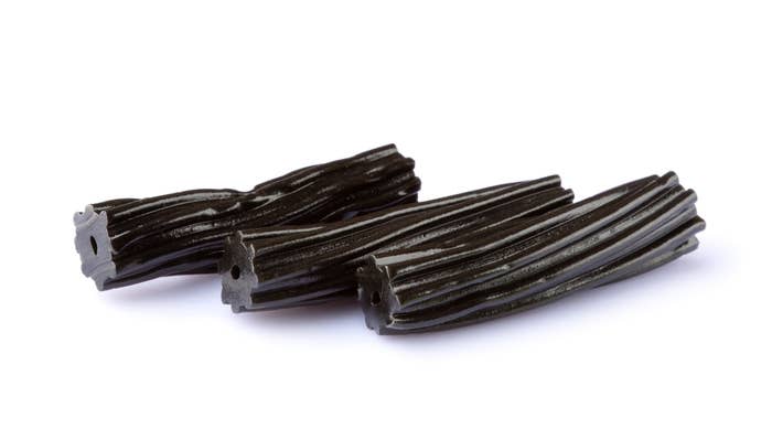 Three pieces of black licorice on a white background