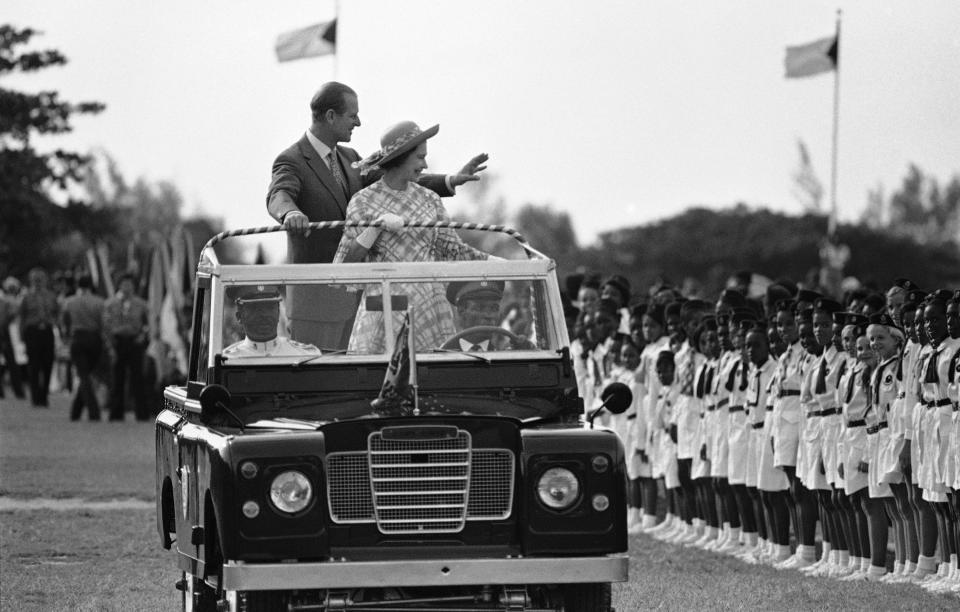 FILE - In this Wednesday, Oct. 15, 1977 file photo, Britain's Queen Elizabeth II and Prince Philip wave to young people at Nassau's Clifford Park after their arrival in Nassau, Bahamas. Buckingham Palace says Prince Philip, husband of Queen Elizabeth II, has died aged 99. (AP Photo/Kathy Willens, File)