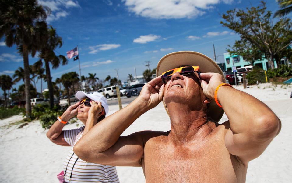 Larry and Judy Hubbard view the solar eclipse on Fort Myers Beach on Monday, April 8, 2024. Fort Myers Beach got a 52% view of the eclipse.