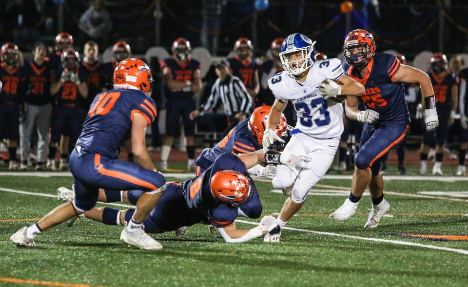 Caldwell's Joey Marinello runs the ball as Mountain Lakes defends during the first half of a football game at Mountain Lakes High School on October 21, 2022.