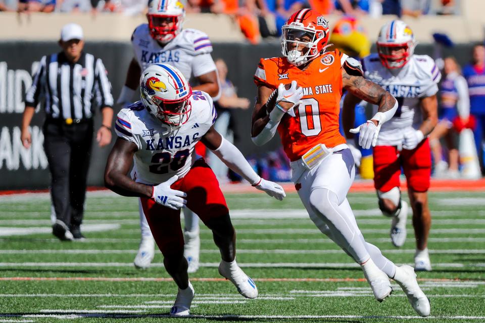 OSU's Ollie Gordon II (0) tries to escape a tackle from Kansas' JB Brown (28) in the first quarter of the Cowboys' 39-32 win on Saturday at Boone Pickens Stadium in Stillwater.