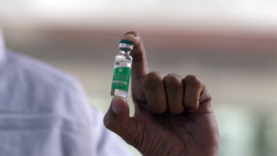 Image: A worker at the Serum Institute of India holding a vial of the Oxford Covid-19 vaccine candidate being produced under the name Covishield. (Sheldon Healy / NBC News)