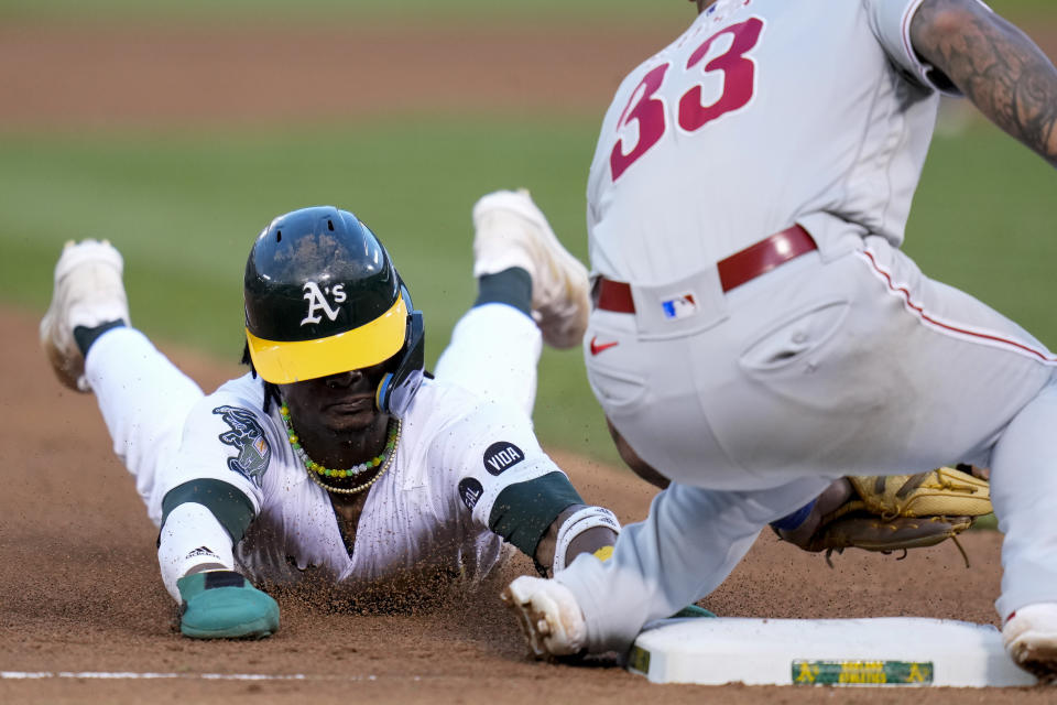 Oakland Athletics' Esteury Ruiz, left, steals third base next to Philadelphia Phillies third baseman Edmundo Sosa (33) during the sixth inning of a baseball game against the Philadelphia Phillies in Oakland, Calif., Friday, June 16, 2023. (AP Photo/Godofredo A. Vásquez)