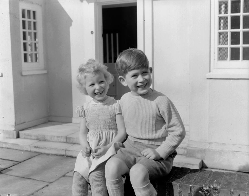 7th April 1954:  Prince Charles and Princess Anne sitting outside the Welsh House, a miniature house donated to the Royal Family by the people of Wales in the grounds of Windsor Castle, Berkshire.  (Photo by Lisa Sheridan/Studio Lisa/Hulton Archive/Getty Images)