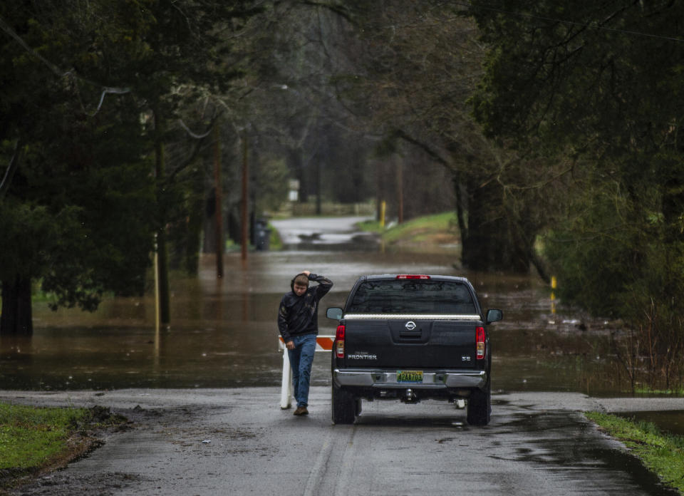 A passerby stops to look over Jackson Street in Courtland after being closed due to flooding on Friday afternoon, Feb. 22, 2019, in Decatur, Ala. (Dan Busey/The Decatur Daily via AP)