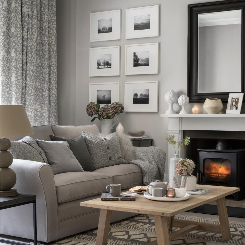 Grey living room with grey sofa and burning woodburner