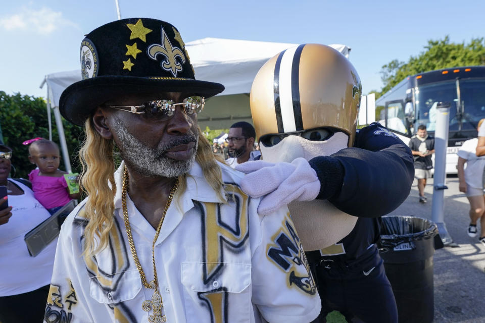 New Orleans Saints mascot "Sir Saint" signs the shirt of fan "Dat Pimp" during the Back Together Weekend fan appreciation initiative at the NFL team's football training camp in Metairie, La., Saturday, July 29, 2023. (AP Photo/Gerald Herbert)