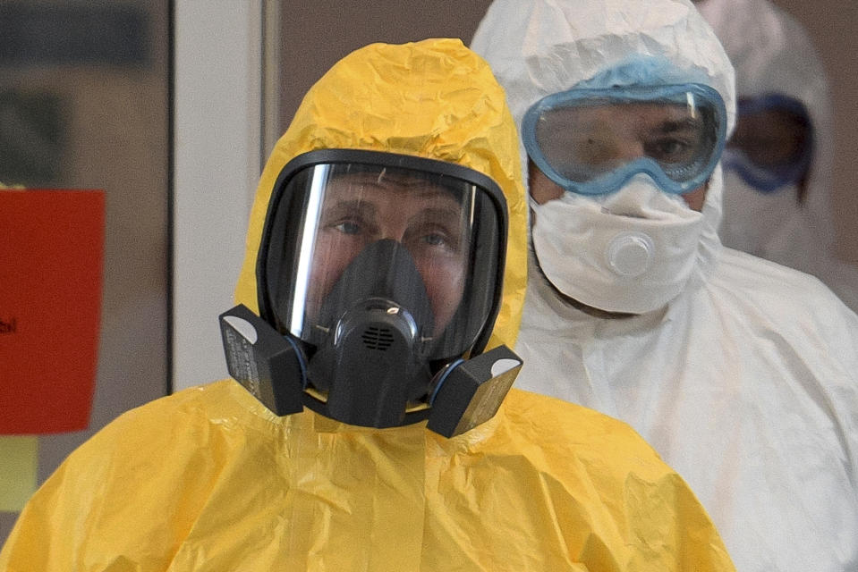 Russian President Vladimir Putin wearing a protective suit enters a hall during his visit to the hospital for coronavirus patients in Kommunarka, outside Moscow, Russia, Tuesday, March 24, 2020. For some people the COVID-19 coronavirus causes mild or moderate symptoms, but for some it can cause severe illness including pneumonia. (Alexei Druzhinin, Sputnik, Kremlin Pool Photo via AP)