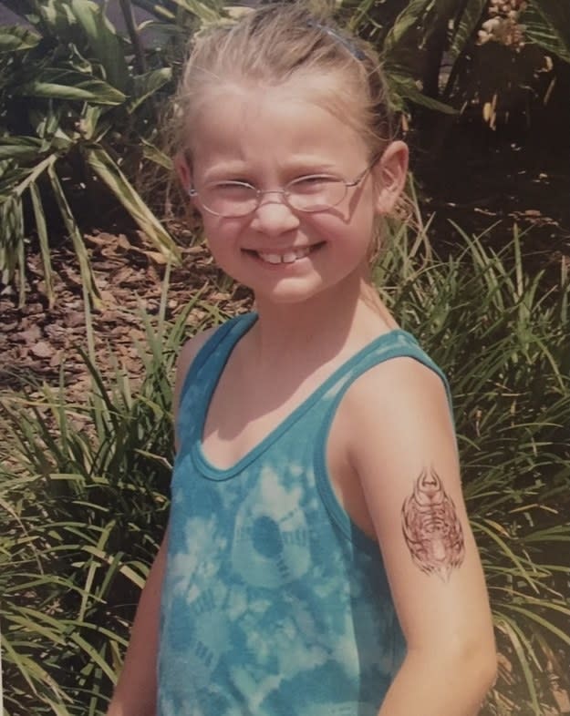 young girl in a tank top with a fake tattoo on her arm