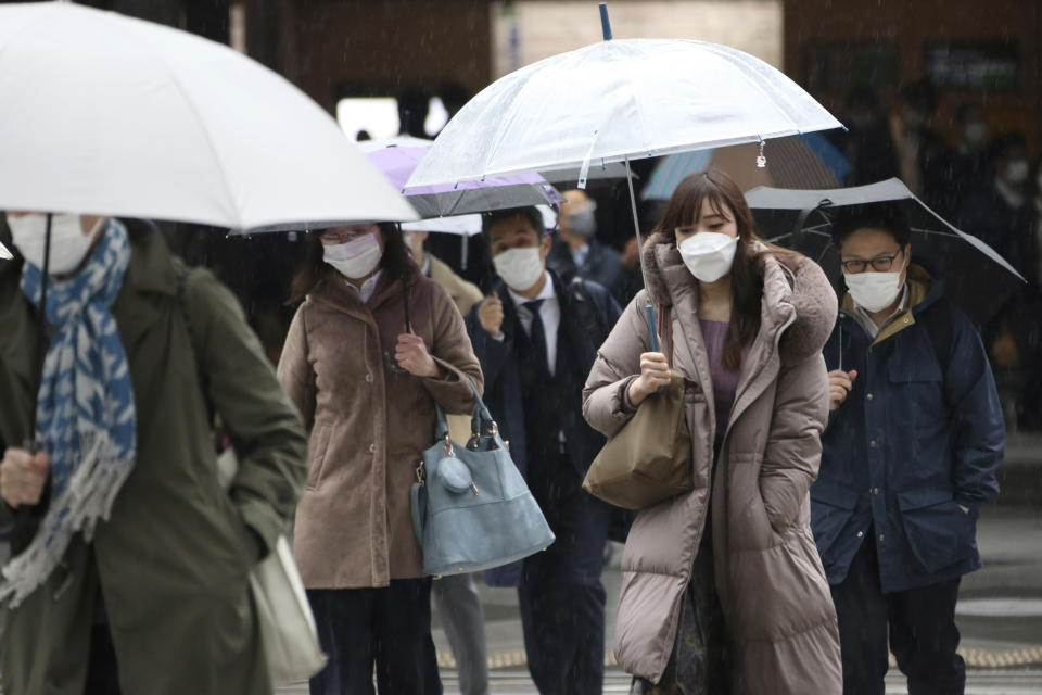 People wearing face masks to protect against the spread of the coronavirus walk at a crossing in Tokyo, Monday, Feb. 15, 2021. Tokyo is under state of emergency as the government seeks to stop a surge of new coronavirus infections. (AP Photo/Koji Sasahara)