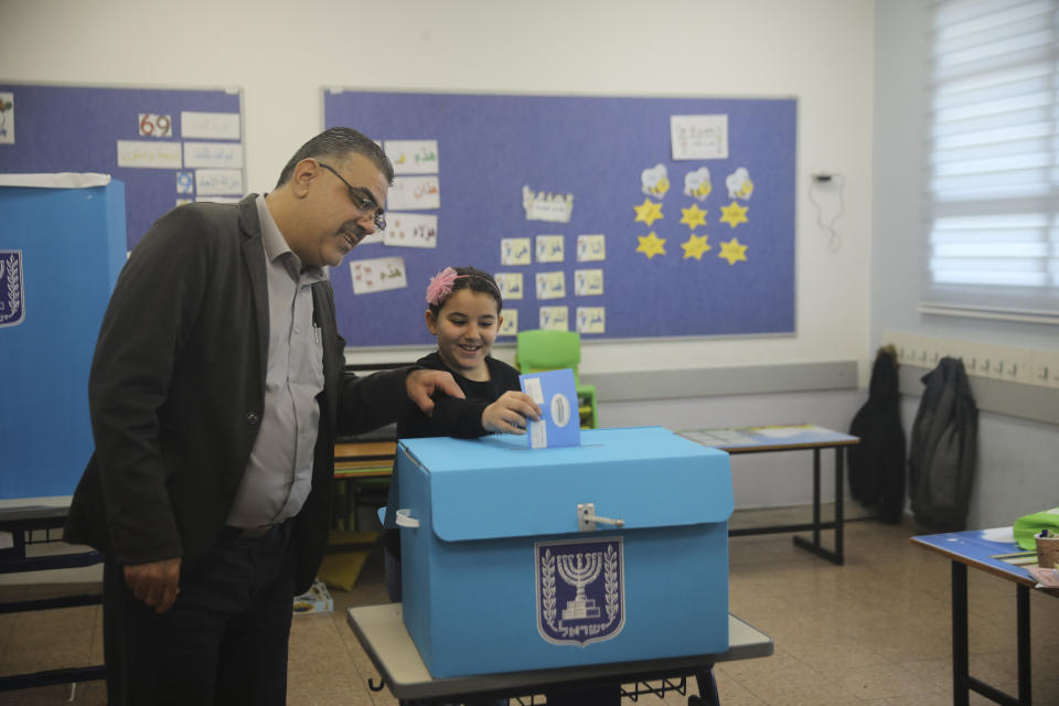 A man and his daughter vote during elections in Tamra, an Arab town in Israel, Monday, March 2, 2020. (AP Photo/Mahmoud Illean)