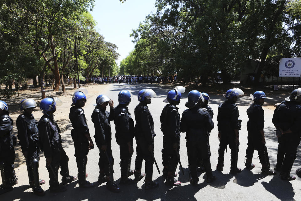 Armed riot police block the road as doctors attempt to march in Harare, Wednesday, Sept, 18, 2019. Zimbabwean doctors protesting the alleged abduction of a union leader were met by a line of baton- wielding police in the capital as fears grow about government repression. (AP Photo/Tsvangirayi Mukwazhi)