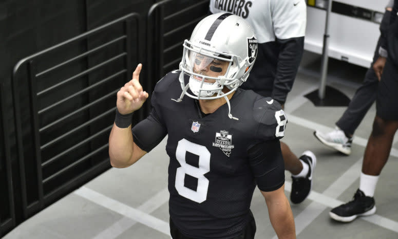 Raiders quarterback Marcus Mariota points to the sky while walking.