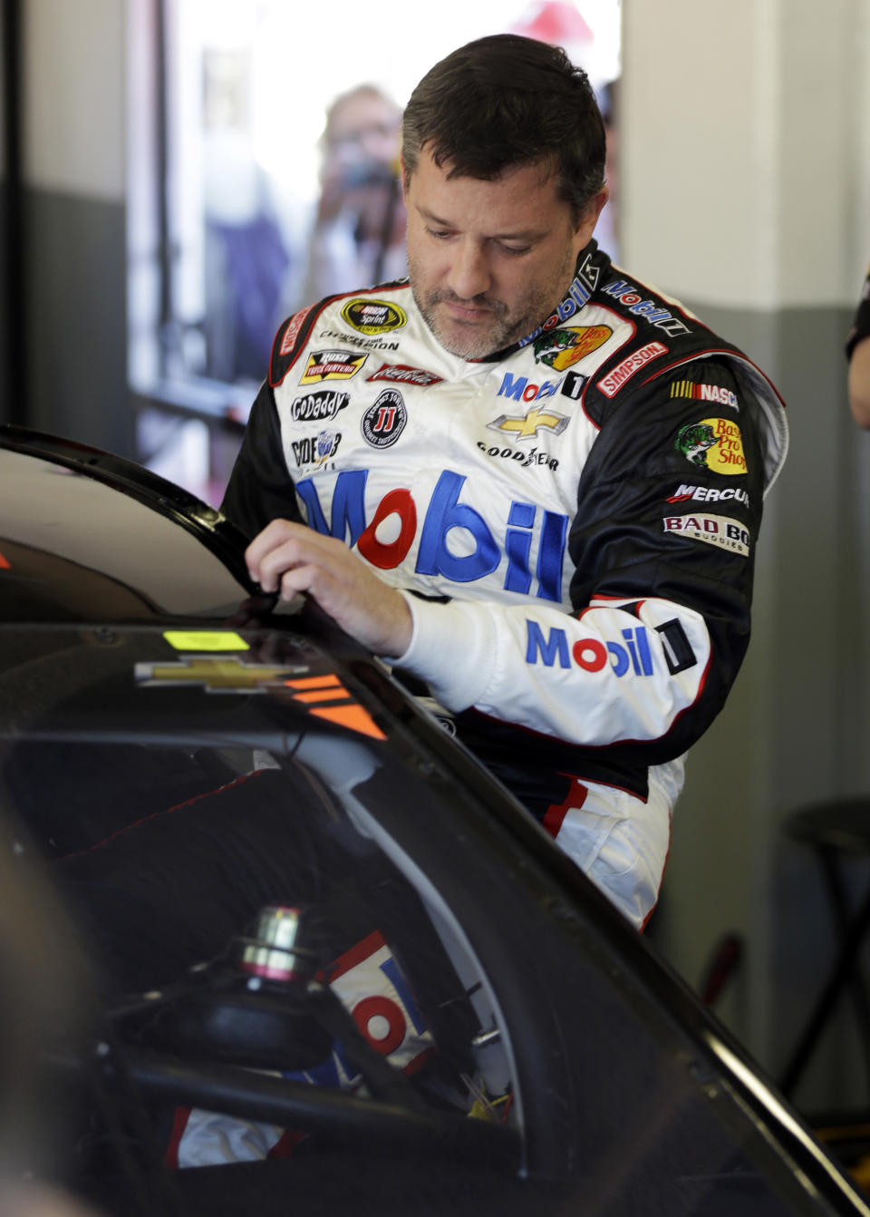 Driver Tony Stewart climbs in his car before practice for the NASCAR Sprint Unlimited auto race at Daytona International Speedway in Daytona Beach, Fla., Friday, Feb. 14, 2014. Stewart has not raced in more than six months since he broke two bones in his leg in an August 2013 sprint-car crash.(AP Photo/John Raoux)