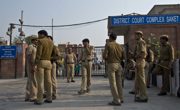 Police stand guard outside the Saket district court in New Delhi on March 12, 2013. An Indian villager axed to death four women and five young girls on Thursday while apparently mentally disturbed after his wife left him, police said