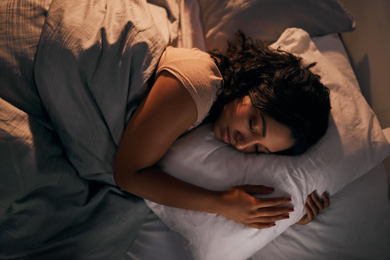 High angle shot of a beautiful young woman sleeping in her bed at home during the night daylight savings time