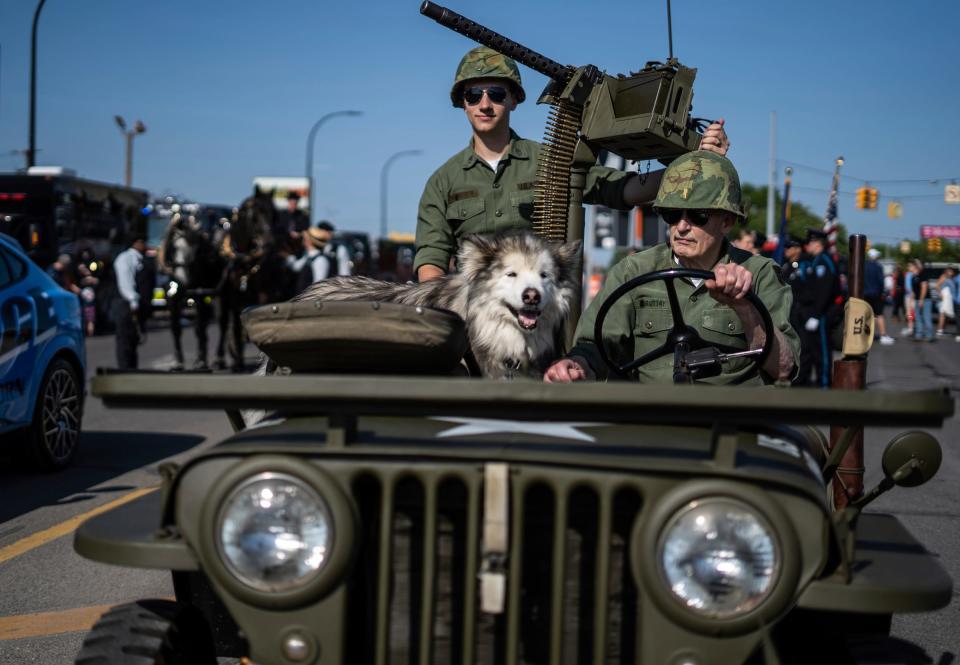 Rich Margittay, right, drives his 1949 Willys Jeep with his dog Cheyenne and Garret Wasko of Taylor before the start of the 97th annual Memorial Day parade along Michigan Avenue in Dearborn on Monday, May 29, 2023.