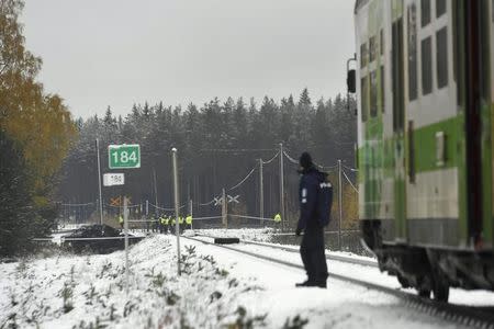 Rescue and military personnel and a policeman are seen at the railroad crossing after a crash between a train and a military truck in Raasepori, Southern Finland, October 26, 2017. LEHTIKUVA/Markku Ulander/via REUTERS