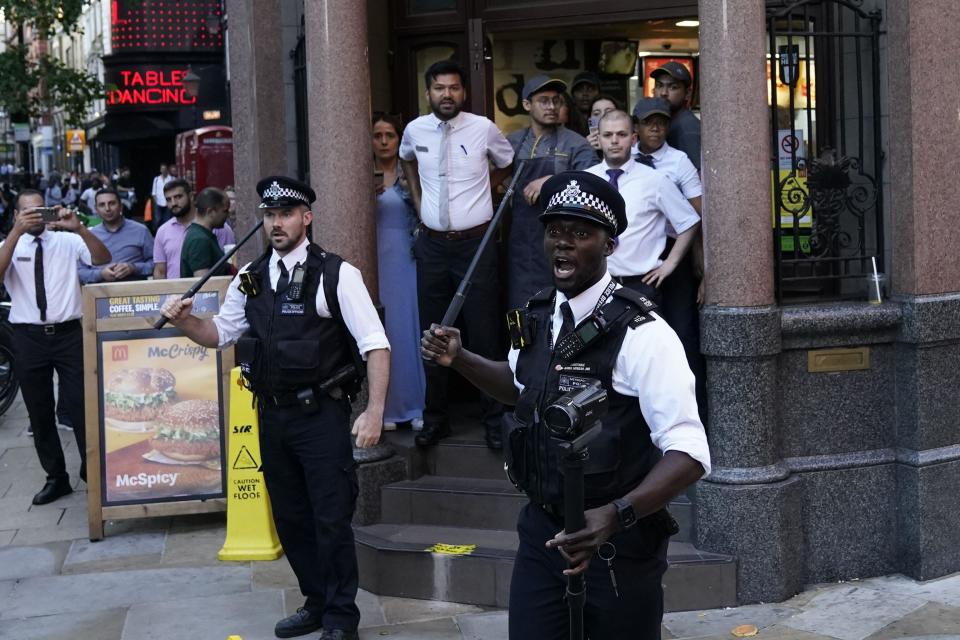 Police officers with batons outside a McDonalds store on Oxford Street in central London. Picture date: Wednesday August 9, 2023.