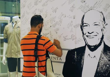 A fan of Dominican-born fashion designer Oscar de la Renta leaves messages of condolence in the window of a store carrying his brand in Santo Domingo, October 22, 2014. REUTERS/Ricardo Rojas