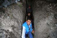 Local residents take shelter in a dugout during the fighting over the breakaway region of Nagorno-Karabakh in the city of Terter