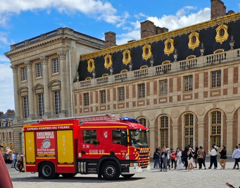 Turistas evacuados por un incendio en el Palacio de Versalles. (Foto X).