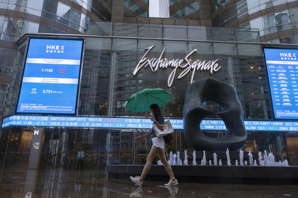 A pedestrian passes by the electronic screen of the Hong Kong Stock Exchange in Hong Kong, Tuesday, June 6, 2023. Asian stock markets rose Tuesday after Wall Street fell on concern the U.S. economy may be weakening following a report that showed growth in service industries slowing.(AP Photo/Louise Delmotte)