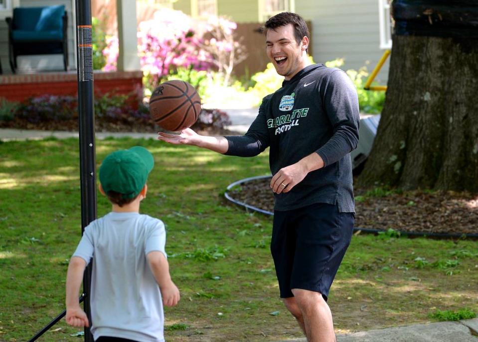 Charlotte 49ers head football coach Will Healy, right, reacts after his son, Eli, 5 yrs., made a basket during a game of Around the World on Tuesday, April 14, 2020.