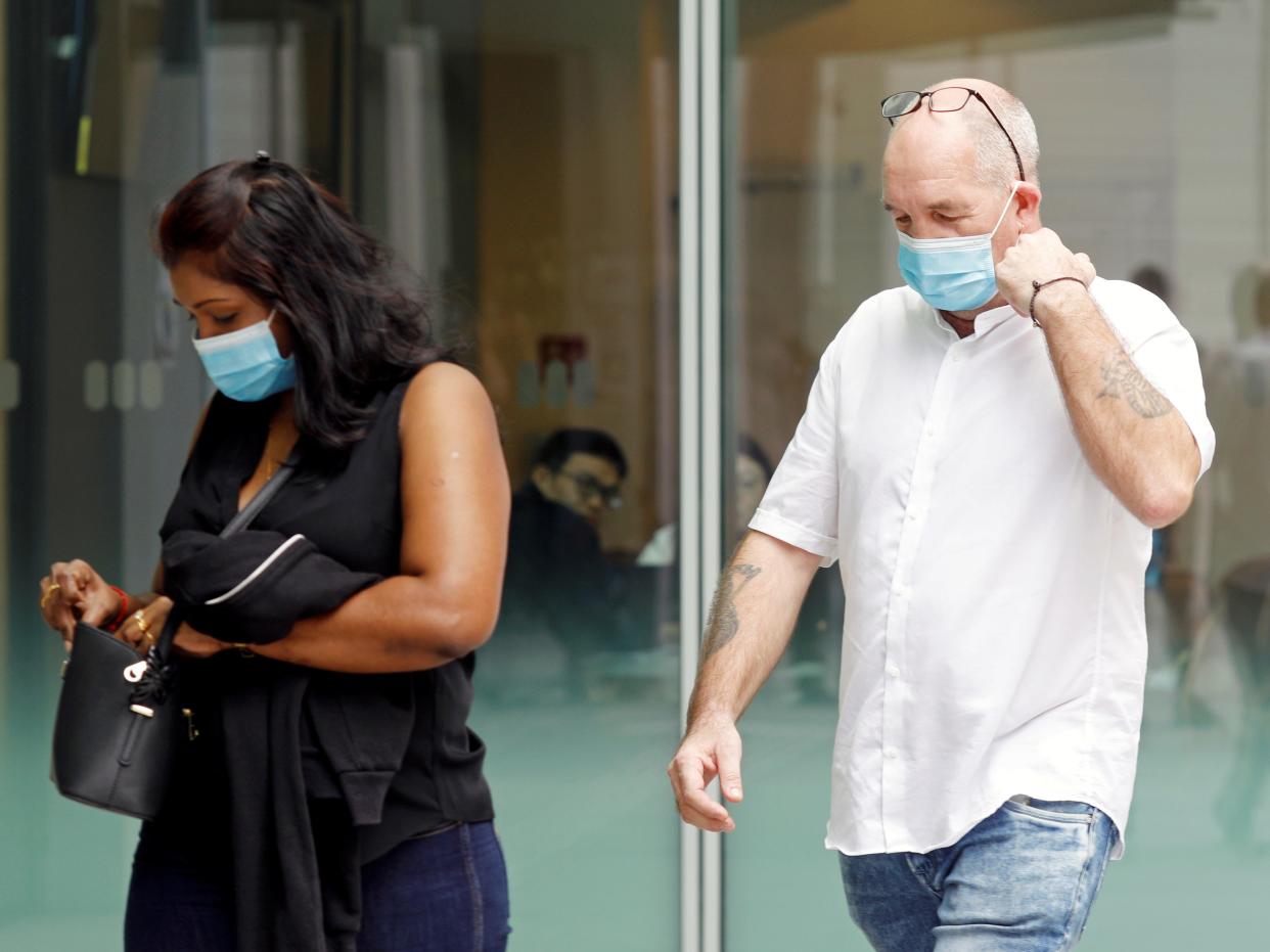 Briton Skea Nigel and partner Agatha Maghesh Eyamalai arrive at the State Courts for a hearing after breaking coronavirus disease (COVID-19) quarantine regulations in Singapore February 15, 2021. REUTERS/Edgar Su