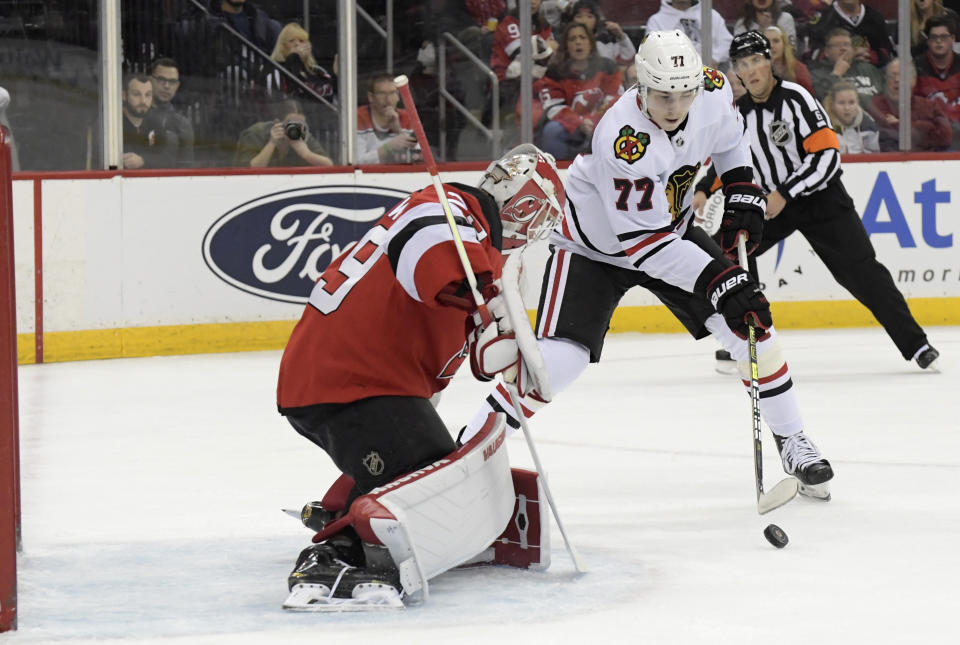 Chicago Blackhawks center Kirby Dach (77) attempts to shoot against New Jersey Devils goaltender Mackenzie Blackwood (29) during the first period of an NHL hockey game Friday, Dec. 6, 2019, in Newark, N.J. (AP Photo/Bill Kostroun)