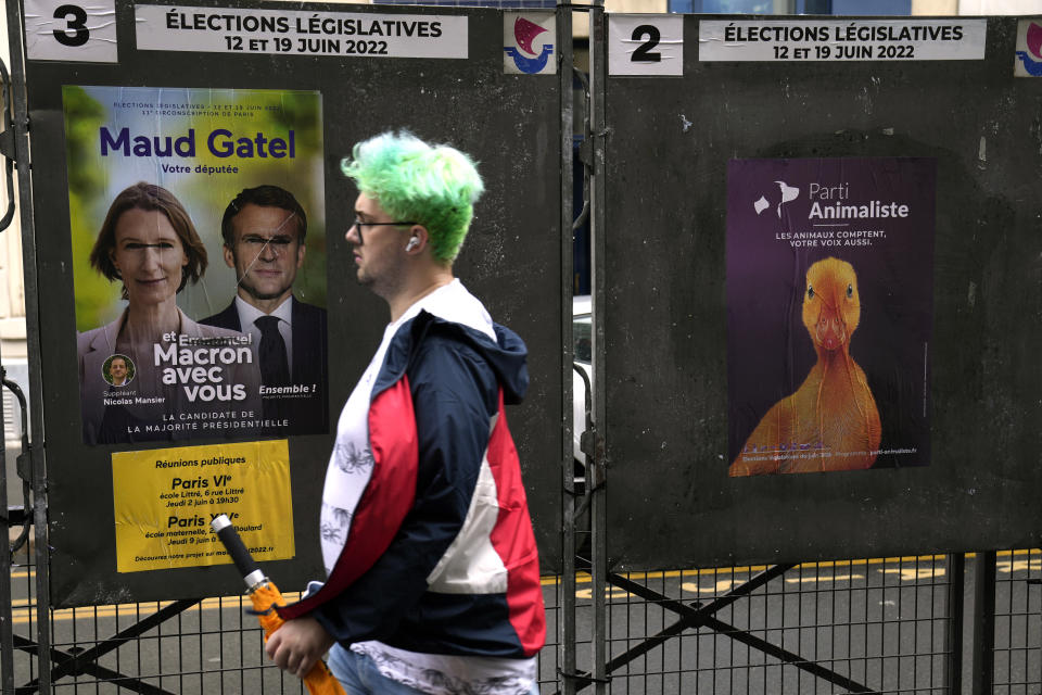 A man walks past electoral posters of the upcoming parliamentary elections in Paris, Wednesday, June 8, 2022. The legislative elections will take place on June 12 and 19, 2022. (AP Photo/Francois Mori)