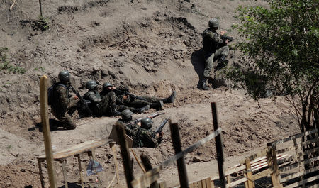 Brazilian Army soldiers take cover during a shootout with drug gangs during an operation in Alemao slums complex in Rio de Janeiro, Brazil August 20, 2018. REUTERS/Ricardo Moraes