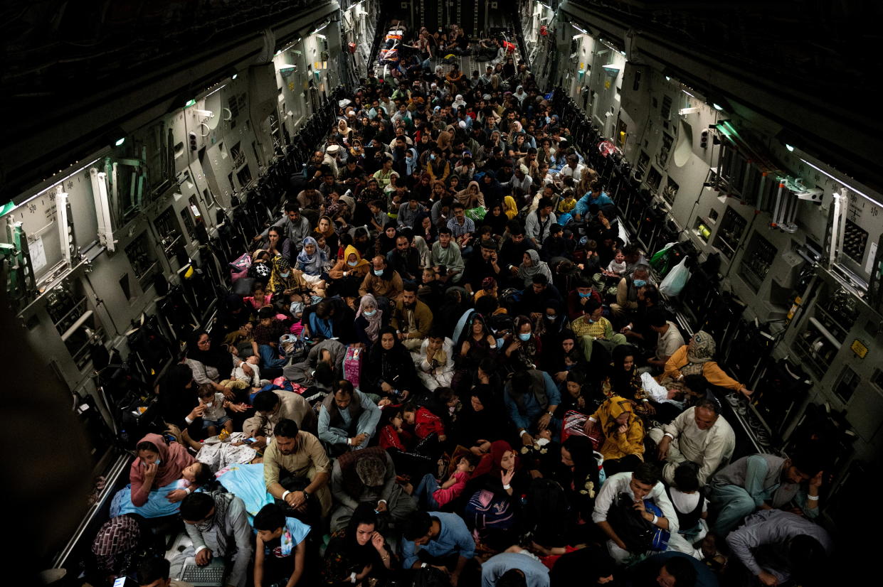 Evacuees from Afghanistan sit inside a military aircraft during an evacuation from Kabul, in this photo taken on August 19, 2021 at undisclosed location and released on August 20, 2021. ( Staff Sgt. Brandon Cribelar/U.S. Marine Corps/Handout via Reuters)