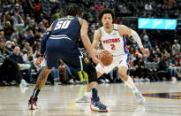 Detroit Pistons guard Cade Cunningham, back, drives to the rim as Denver Nuggets forward Aaron Gordon defends in the first half of an NBA basketball game Sunday, Jan. 23, 2022, in Denver. (AP Photo/David Zalubowski)