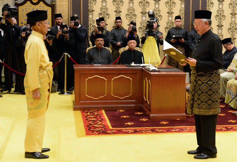 Malaysia's Prime Minister Najib Razak (right) reads his oath in front of Malaysia's King Abdul Halim Mu'adzam Shah as he is sworn in for his second term as prime minister at the National Palace in Kuala Lumpur on May 6, 2013, in a photo released by the Malaysia Information Ministry