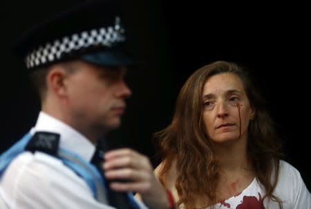 Una activista de Extiction Rebellion observa a un oficial de policía mientras protesta durante la Semana de la Moda de Londres en Londres, Reino Unido