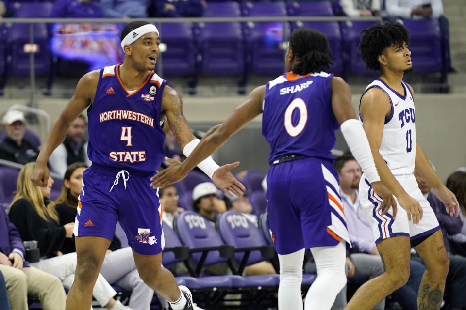Northwestern State guard JaMonta' Black (4) celebrates his score with teammate Demarcus Sharp (0) in front of TCU guard Micah Peavy (0) in the final minutes of the second half of an NCAA college basketball game in Fort Worth, Texas, Monday, Nov. 14, 2022. Northwestern State won 64-63. (AP Photo/LM Otero)