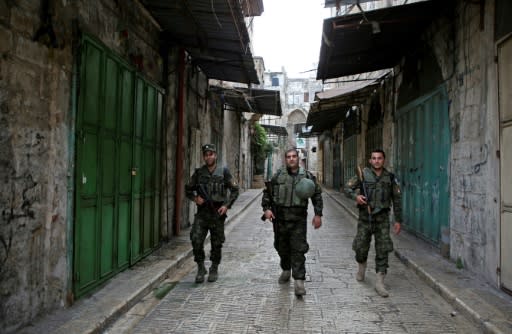 Members of the Palestinian security forces walk past closed shops during a general strike in the Old City of Nablus in the occupied West Bank on October 1, 2018