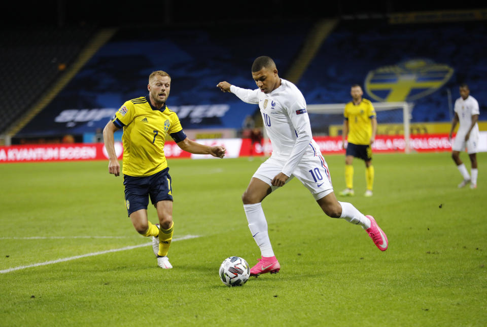 Kylian Mbappé de Francia tira a gol mientras lo persigue Sebastian Larsson de Suecia en el primer juego de la Liga de Nacionales en el Friends Arena en Estocolmo el sábaod 5 de septiembre del 2020. (Christine Olsson/TT via AP)